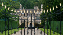 driveway-to-large-historic-manor-house-through-ornate-gates.jpg