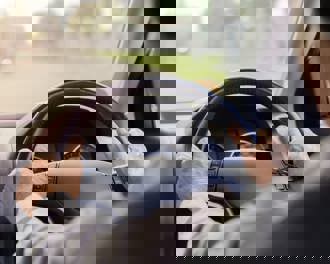 Senior adult hands on wheel