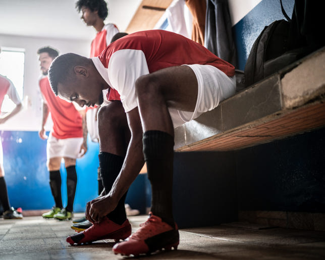 Football player tying shoelace