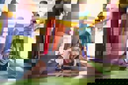 Boy and girl having fun jumping in inflatable castle playground.